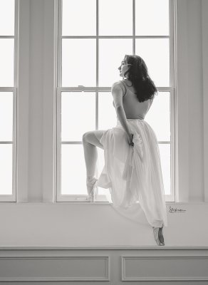 Abllerina posing in a window sill in balck and white