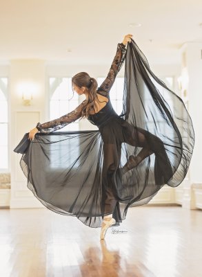 ballerina in a pique pose yet showing off her black flowing skirt