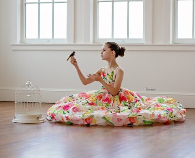 young dancer with a flower dress holding a bird
