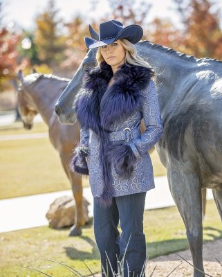 woman in a snake print fur coat in front of a horse statue